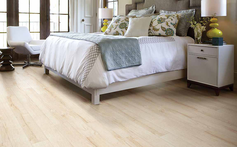 warm toned wood look laminate flooring in a bright bedroom