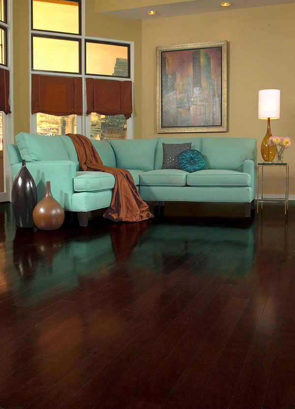 Teal pastel colored couch on dark brown wood floor