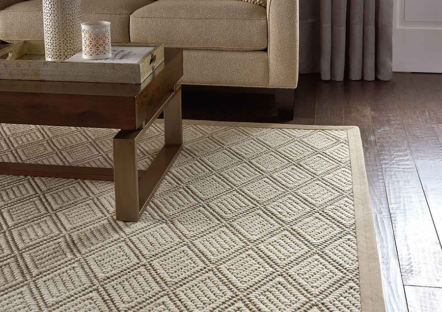 Beige patterned area rug under a coffee table in a living room