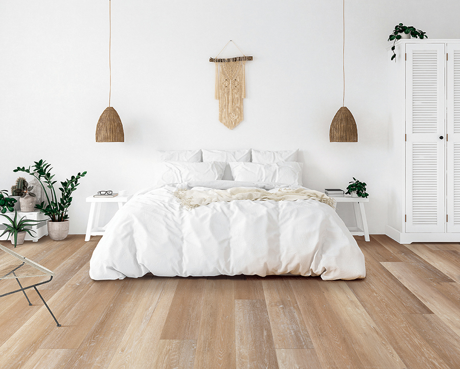 Scandinavian inspired bedroom with a comfy bed and light, white-washed luxury vinyl floors