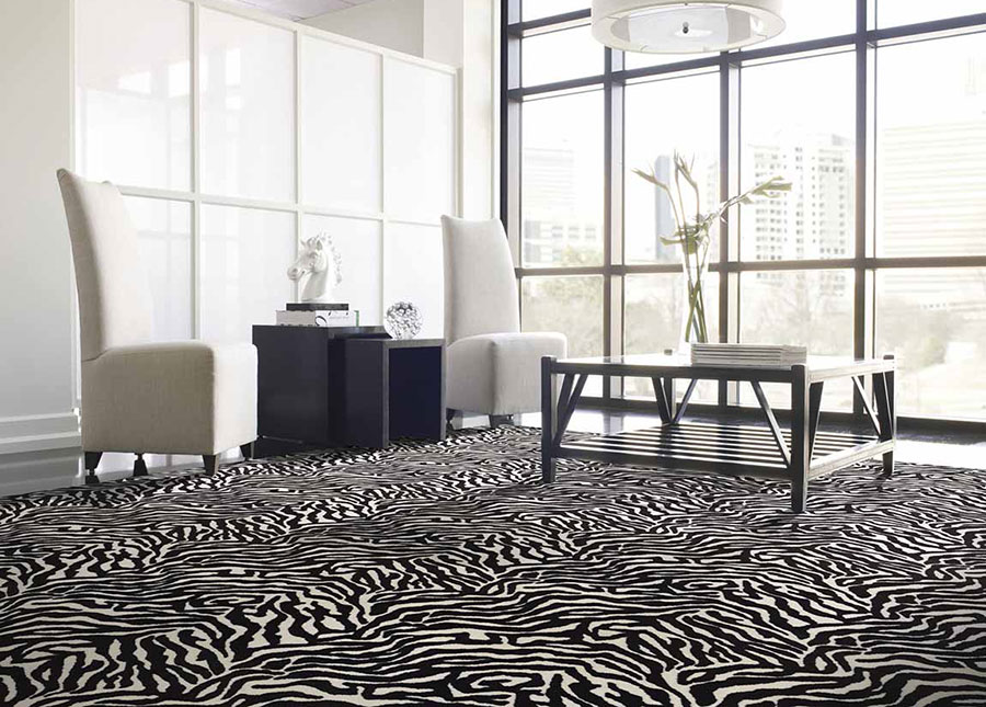 Living room with white high back chairs and black end tables on black and white zebra print rug.
