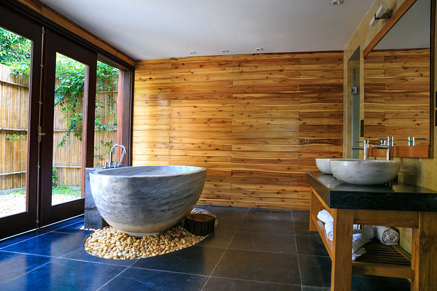 Luxury resort spa themed bathroom with blue tile floor and freestanding soaking tub 