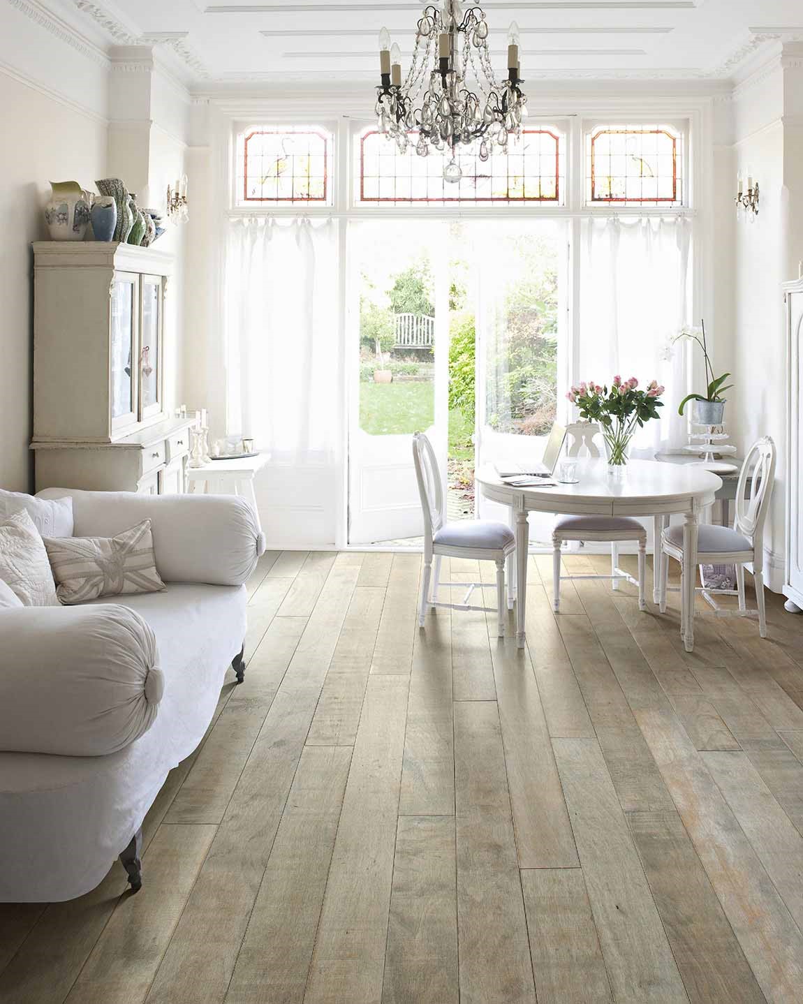 bright living room with white furniture and light hardwood flooring