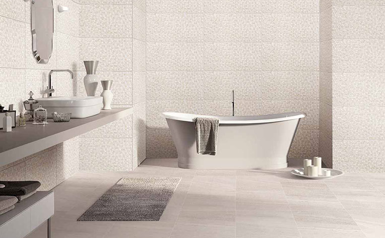Modern home bathroom with large white soaking tub, a white washbowl sink on a grey countertop, and tiled floor and walls.