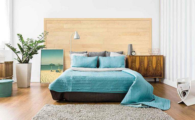 Bedroom with teal bedspread and beach photo for a resort look