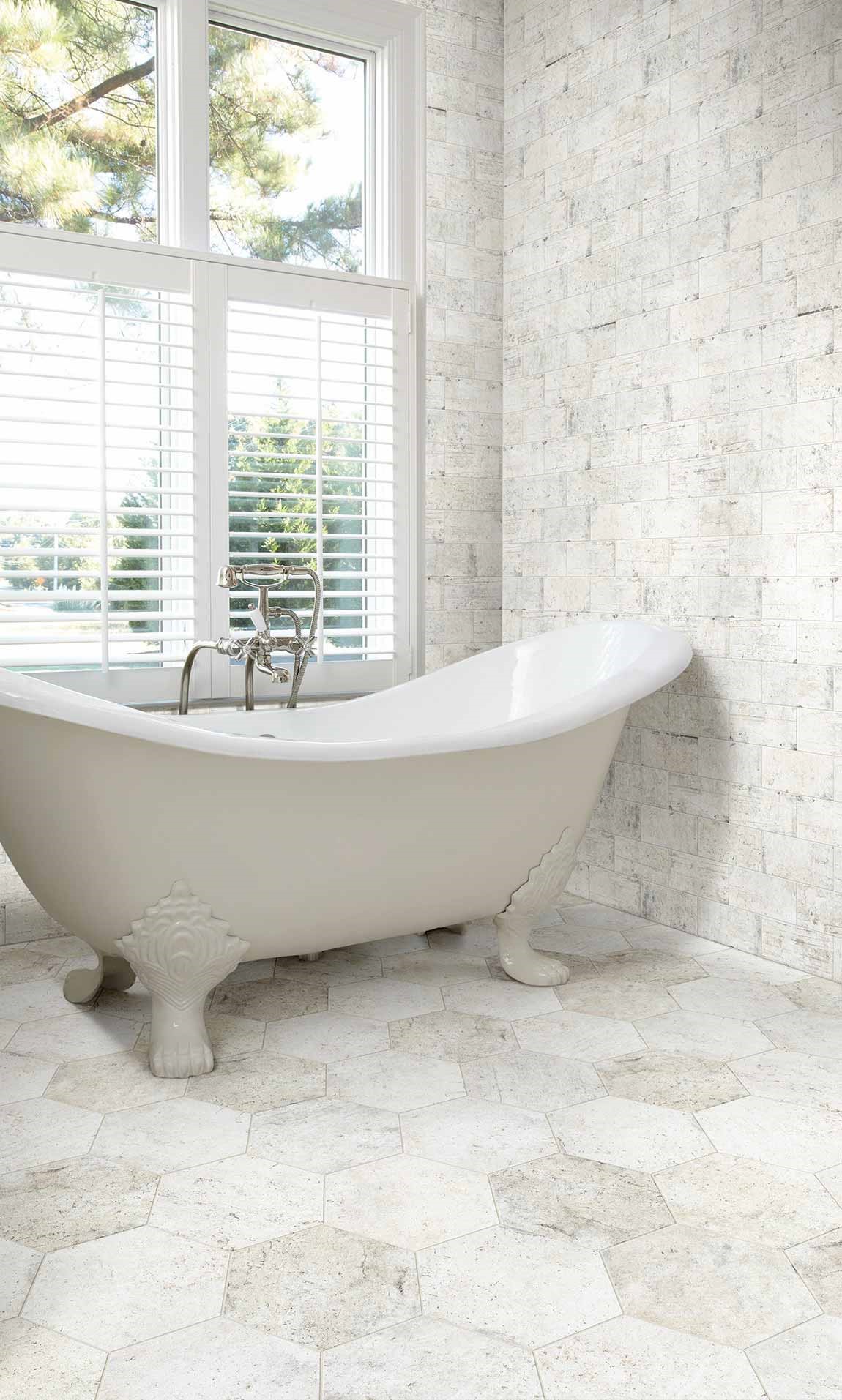 reestanding bathtub in light colored bathroom with ceramic tile