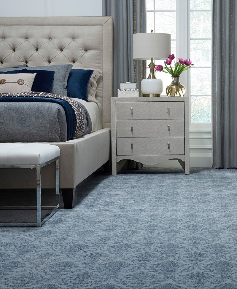 master bedroom and sidetable with blue pattern carpet