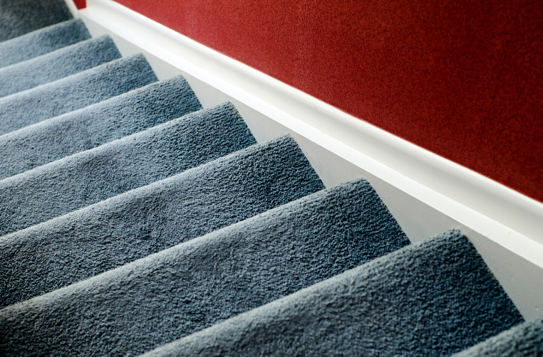 Blue-grey carpet on the stairs leading to the second floor of a house